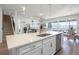 Bright, white kitchen features a large island with sink overlooking the living room and dining area at 7649 Ragusa Way, Clermont, FL 34714