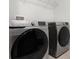 Modern laundry room featuring Samsung washer and dryer, with convenient overhead shelving at 7649 Ragusa Way, Clermont, FL 34714