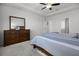 Spacious main bedroom with a dresser and mirror, fan, and ensuite bathroom at 7649 Ragusa Way, Clermont, FL 34714