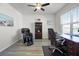 Home office featuring wood floors, a ceiling fan, window, desk, chair and massage chair at 7649 Ragusa Way, Clermont, FL 34714