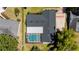 Bird's eye view showcases a screened-in pool and manicured landscaping of this home, set on a well-maintained lawn at 7655 Persian Ct, Orlando, FL 32819