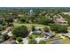 An aerial view showcases the property's prime location on a golf course with mature trees and a nearby pond at 7655 Persian Ct, Orlando, FL 32819