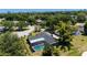 An aerial view of the property, landscaping, and the screened-in pool, all set in a verdant, tree-lined neighborhood at 7655 Persian Ct, Orlando, FL 32819