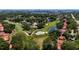 Enjoy this aerial view of a golf course community with lush greenery and mature trees at 7655 Persian Ct, Orlando, FL 32819