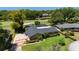 Aerial view of the property showcasing landscaping and the screened pool in relation to a nearby golf course at 7655 Persian Ct, Orlando, FL 32819