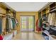 Walk-in closet featuring custom built-ins and a lovely view of the garden at 7655 Persian Ct, Orlando, FL 32819