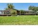 This home boasts an inviting facade with manicured landscaping, mature trees, and a well-kept lawn at 7655 Persian Ct, Orlando, FL 32819