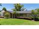 A well-maintained front yard features mature trees and landscaping creating an inviting curb appeal at 7655 Persian Ct, Orlando, FL 32819