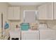 Functional laundry room with utility sink and ample storage cabinets for convenience at 7655 Persian Ct, Orlando, FL 32819
