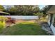 Spacious backyard featuring a well-maintained lawn, white privacy fence, and a charming pergola at 7730 Broken Arrow Trl, Winter Park, FL 32792