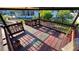 A covered wooden deck featuring a wooden railing, partially worn covering, and potted plants at 7730 Broken Arrow Trl, Winter Park, FL 32792