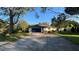 Front view of a traditional home with a wide driveway and a two-car garage at 7730 Broken Arrow Trl, Winter Park, FL 32792