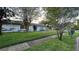 Charming one-story home featuring a lush green lawn, mature trees, and a welcoming entrance at 7730 Broken Arrow Trl, Winter Park, FL 32792