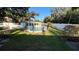 Backyard view of the inviting in-ground pool and manicured lawn surrounded by a white fence at 7730 Broken Arrow Trl, Winter Park, FL 32792