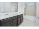 Bright bathroom features a double vanity with modern fixtures and a tiled tub-shower combo at 7831 Dausset St, Orlando, FL 32827