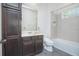 Well-lit bathroom showcasing a dark wood vanity, modern fixtures, and tiled shower with built-in niche at 7831 Dausset St, Orlando, FL 32827