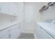 Bright laundry room featuring sleek white cabinets, modern sink and a practical washer-dryer setup at 7831 Dausset St, Orlando, FL 32827