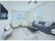 Bright living room with modern seating, neutral decor, and ample natural light from large windows at 7831 Dausset St, Orlando, FL 32827