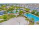 Aerial view of an inviting community pool area with a swimming pool, beach volleyball and many palm trees at 7831 Dausset St, Orlando, FL 32827