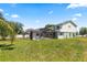 Backyard view of a two-story home with a screened-in pool area and spacious grassy area at 905 Ocala Woods Ln, Orlando, FL 32824