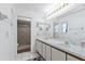 Bright bathroom with double sink vanity, a large mirror, and a tiled walk-in shower at 905 Ocala Woods Ln, Orlando, FL 32824