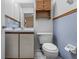 Small bathroom features a toilet, vanity with a white countertop, and a mirror with wood-colored accents at 905 Ocala Woods Ln, Orlando, FL 32824
