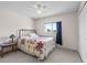 Well-lit bedroom featuring a metal bed frame, ceiling fan, carpet floors, and a large window at 905 Ocala Woods Ln, Orlando, FL 32824