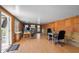 Bright office with wood paneling, laminate flooring, multiple desks and a door leading to the pool at 905 Ocala Woods Ln, Orlando, FL 32824