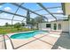 Bright screened-in pool area featuring a turquoise pool, spacious concrete patio, and open backyard at 905 Ocala Woods Ln, Orlando, FL 32824