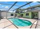 Backyard with a kidney-shaped pool features a screened in patio with a view of the home's windows and doors at 905 Ocala Woods Ln, Orlando, FL 32824