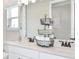 Bright bathroom featuring double sinks, white cabinets, and a decorative towel rack at 1048 Teal Creek St, St Cloud, FL 34771