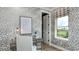Stylish home office features patterned wallpaper, a writing desk, and a window with a backyard view at 1048 Teal Creek St, St Cloud, FL 34771