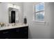 Modern bathroom featuring a black vanity, sleek mirror, and a well-lit window at 11014 Hawkshead Ct, Windermere, FL 34786
