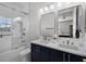 Bright bathroom featuring double sinks, white countertops, and a glass enclosed shower at 11014 Hawkshead Ct, Windermere, FL 34786