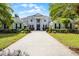 Stately two-story home with a columned entrance, gray exterior, manicured landscaping, and a paver driveway at 11014 Hawkshead Ct, Windermere, FL 34786