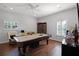Spacious game room with a pool table, hardwood floors, and a large window with plantation shutters at 11014 Hawkshead Ct, Windermere, FL 34786
