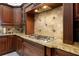 Kitchen with custom wood cabinets, granite countertops, and backsplash with a gas cooktop at 11014 Hawkshead Ct, Windermere, FL 34786
