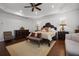 Large main bedroom with hardwood floors, a tray ceiling, custom drapes, and plantation shutters at 11014 Hawkshead Ct, Windermere, FL 34786