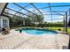 Screened-in pool with a waterfall feature, spa, and ample brick-paved deck space with lush landscaping at 11014 Hawkshead Ct, Windermere, FL 34786