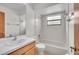 Bathroom with white tile, sink and vanity, toilet, shower and window at 117 Honeywood Dr, Kissimmee, FL 34743