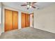 Bedroom includes double closet, neutral walls, carpet, and ceiling fan at 117 Honeywood Dr, Kissimmee, FL 34743