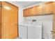Bright laundry room with white washer and dryer and upper cabinets at 117 Honeywood Dr, Kissimmee, FL 34743