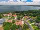 Community aerial view with mature trees, nicely manicured lawns, and lake views in the background at 12222 Cypress Landing Ave, Clermont, FL 34711