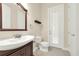 Half bath with tiled floors, a white toilet, and a wooden vanity with a dark finish at 12222 Cypress Landing Ave, Clermont, FL 34711