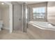 This bathroom boasts a glass enclosed shower, corner tub, and tile flooring at 12222 Cypress Landing Ave, Clermont, FL 34711