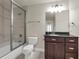 This bathroom includes a shower-tub combo, toilet, and vanity with dark cabinetry at 12222 Cypress Landing Ave, Clermont, FL 34711