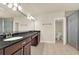 This spacious bathroom features a double vanity with dark wood cabinets and a tile floor at 12222 Cypress Landing Ave, Clermont, FL 34711