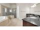 Bright bathroom featuring double vanities, soaking tub, and glass-enclosed shower at 12222 Cypress Landing Ave, Clermont, FL 34711