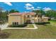 Inviting two-story home with lush landscaping, a terracotta roof, and a stately palm tree at 12222 Cypress Landing Ave, Clermont, FL 34711