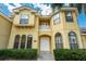Stately two-story home featuring a private balcony, arched windows, and elegant double doors at 12222 Cypress Landing Ave, Clermont, FL 34711